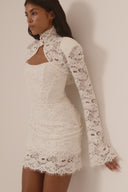 Woman wearing a white mini lace dress with jacket